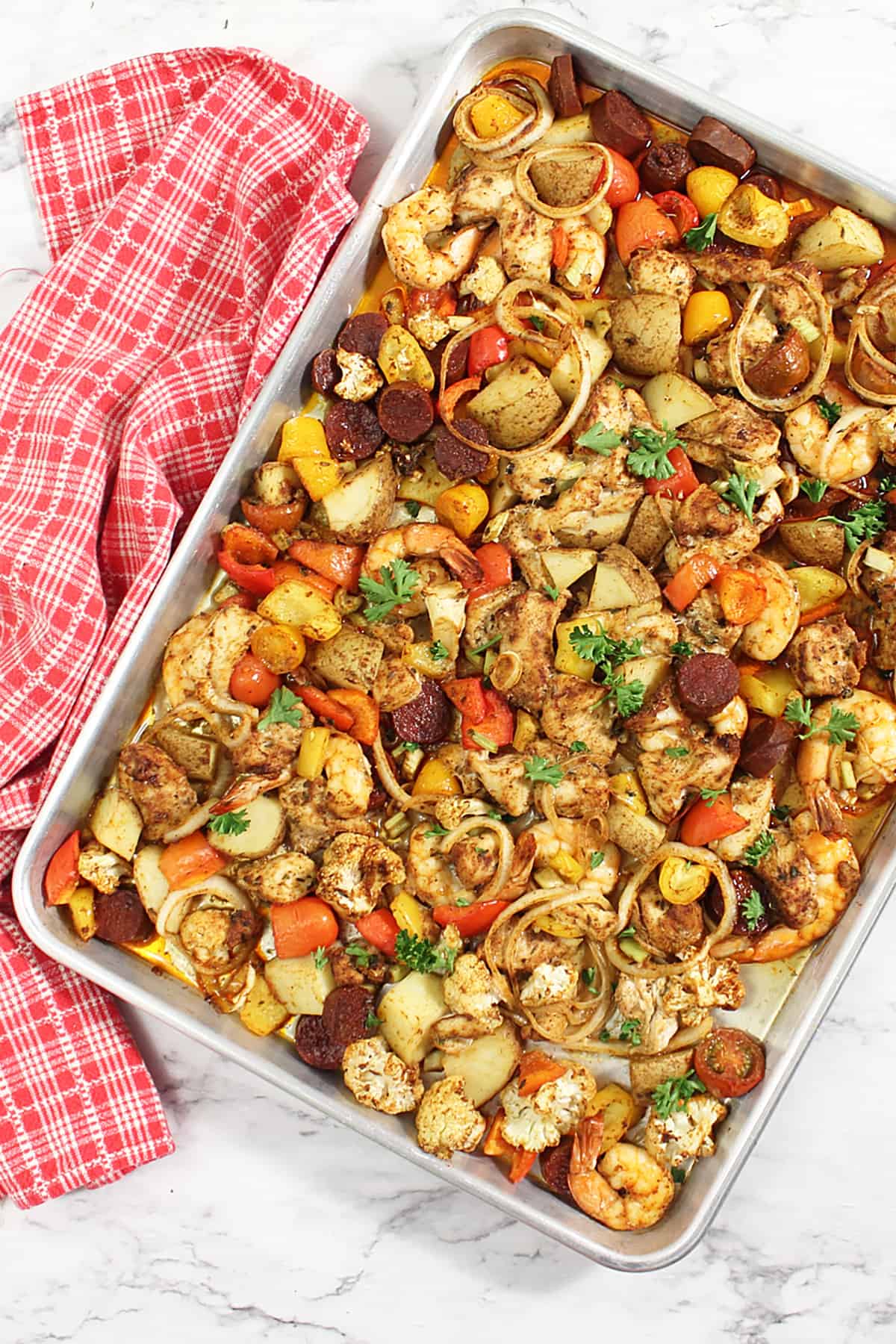 Overhead of creole chicken and shrimp sheet pan dinner on cookie sheet.