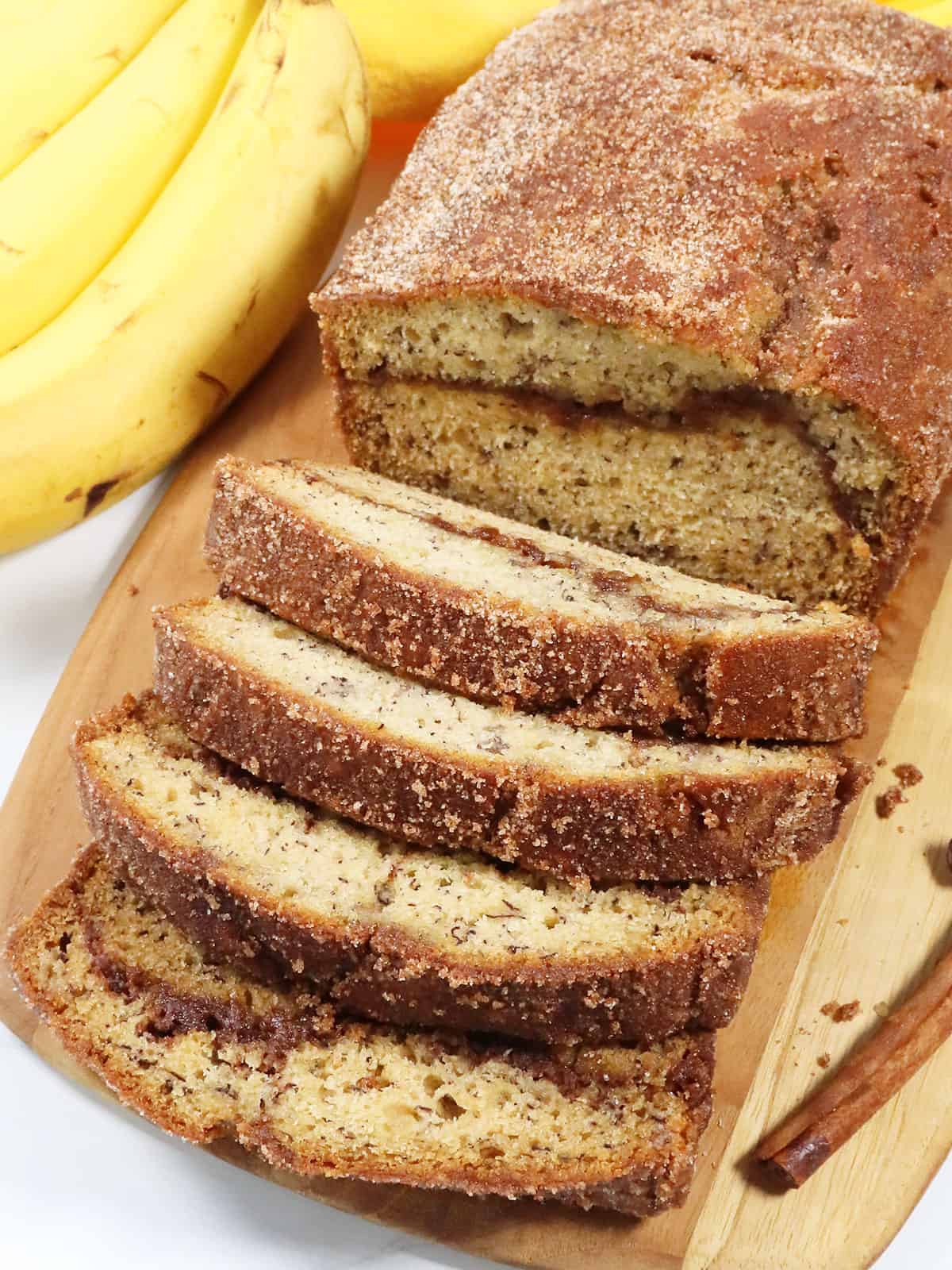 Sliced Cinnamon Banana Bread on wooden board.