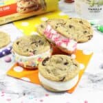 Chocolate chip ice cream sandwiches scattered on table.