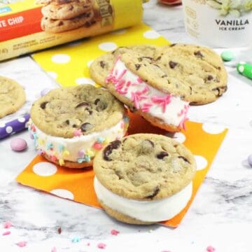 Chocolate chip ice cream sandwiches scattered on table.