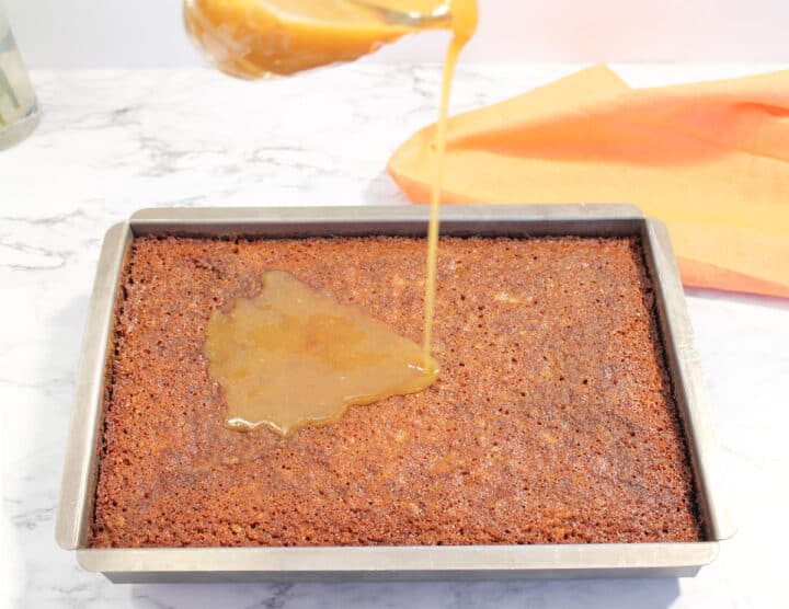 Pouring buttermilk glaze over baked carrot cake.
