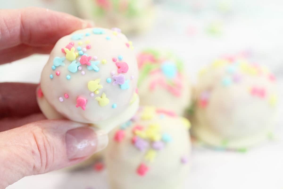 Holding a cake ball to show Easter sprinkles.