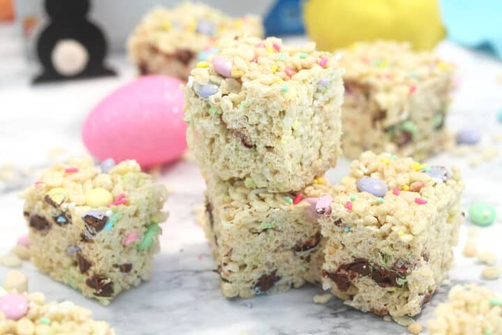 Stacks of treats on white marble with pink egg in background.