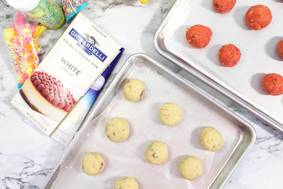 Lemon Cake Balls and Strawberry Cake Balls on cookie sheets.