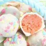 Showing halved strawberry cake ball on top of more.