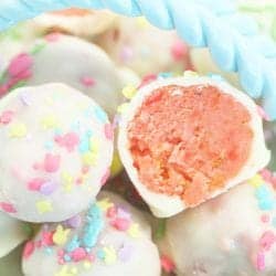 Showing halved strawberry cake ball on top of more.