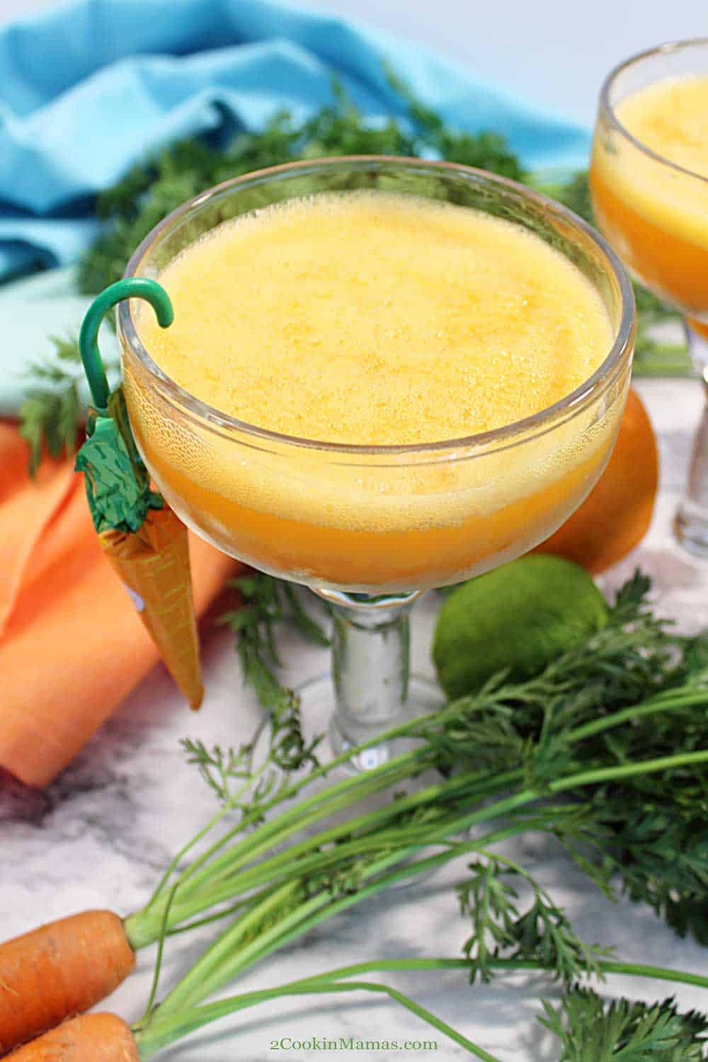 Single Easter Carrot Margarita | 2 Cookin Mamas Carrot Margaritas are a delicious spin on the classic margarita with carrot juice added to the mix! They have the standard tequila and lime juice, sweetened with orange juice and a little sugar, then a splash to two of carrot juice. A refreshing seasonal cocktail that no one will guess has something healthy in it! #margarita #cocktail #Easter #spring #drink #carrotjuice #limes #tequila #recipe #easy