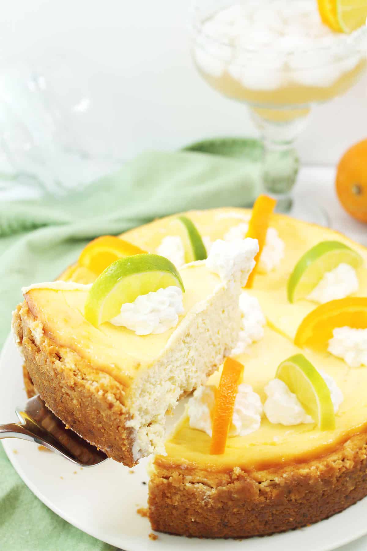 Lifting slice of cheesecake out of garnished margarita cheesecake.
