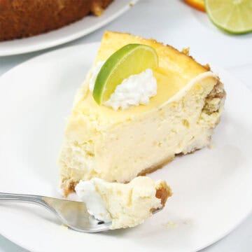 Slice of lime margarita cheesecake om plate with bite on fork.