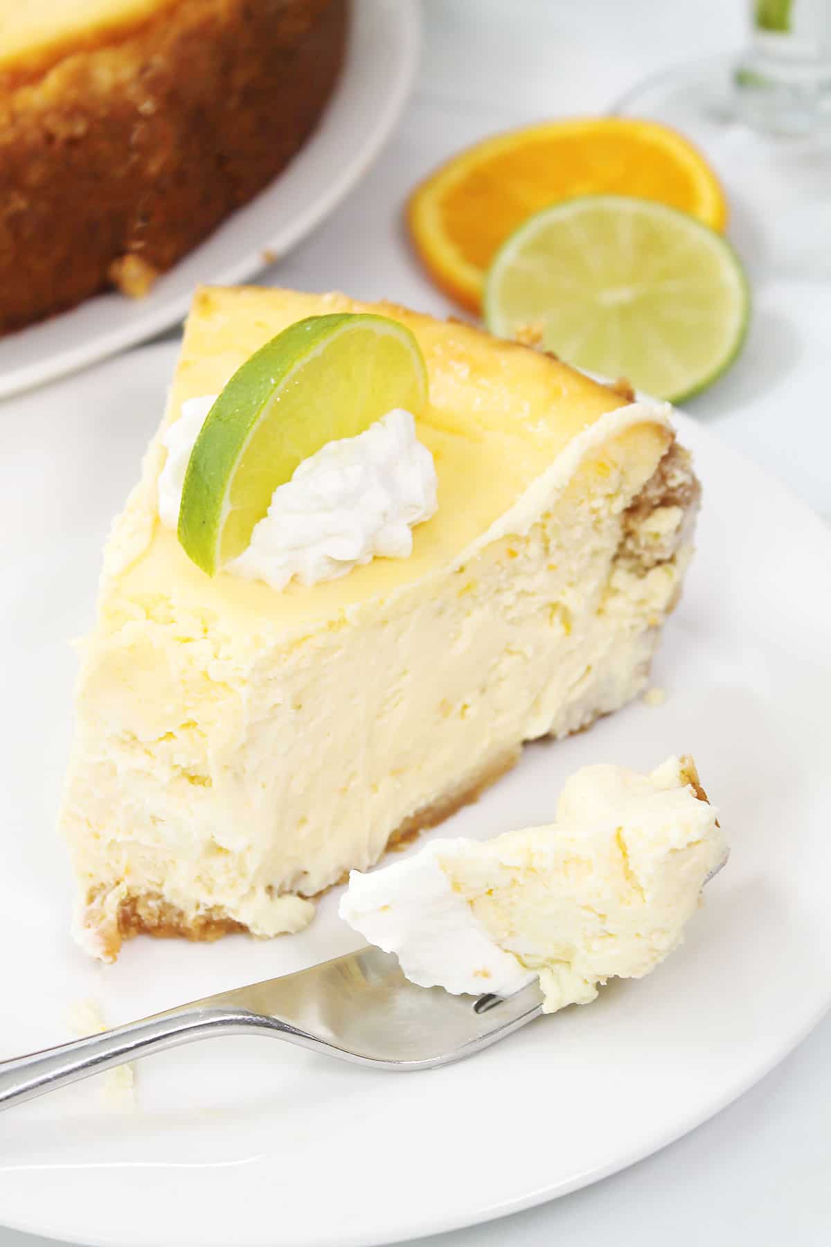 Slice of cheesecake with bite on fork.