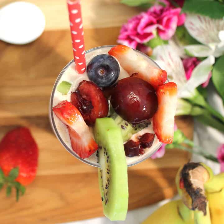 Overhead of single cherry and vanilla smoothie with garnishes.