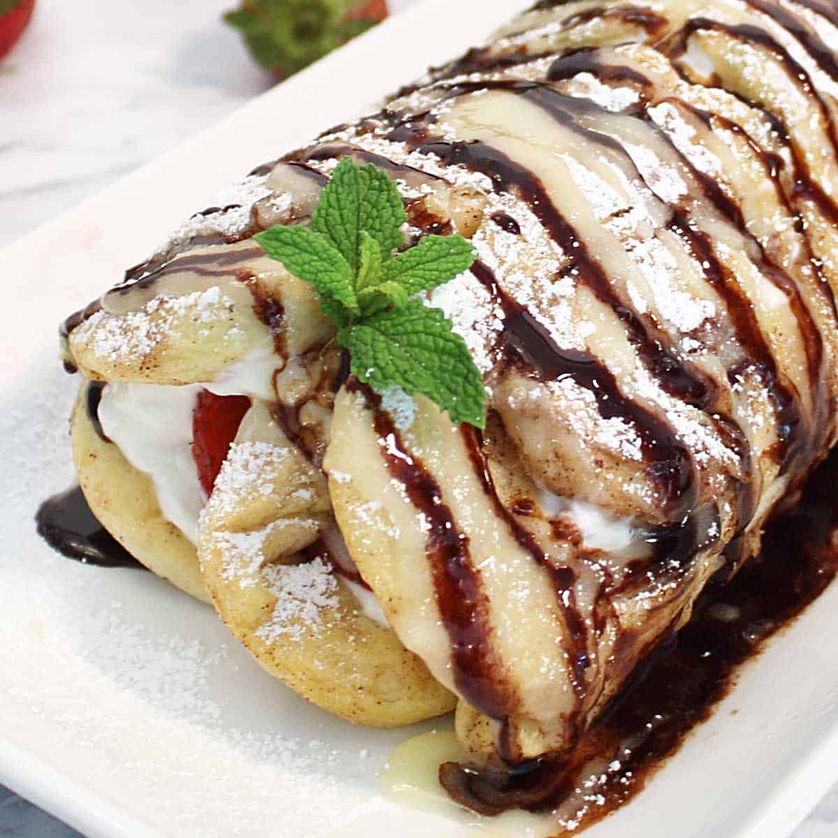 Close view of finished cinnamon roll with strawberries.