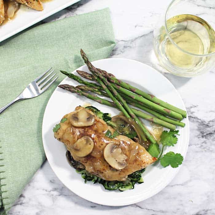 Chicken Chablis with Mushrooms and Asparagus on a White Plate.