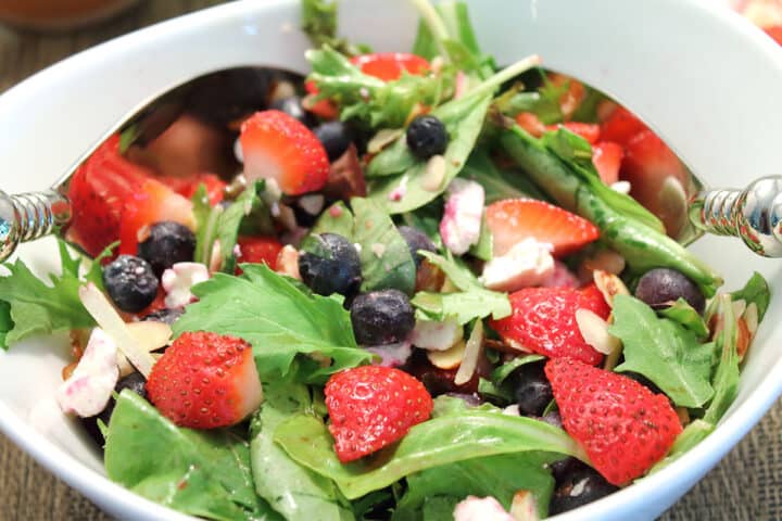Closeup of mixed berry salad in white bowl.