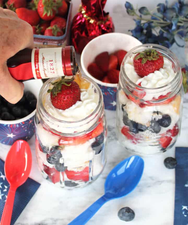 Pouring Grand Marnier into mason jar parfaits.