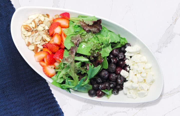 Red white and blue salad deconstructed on marble table.