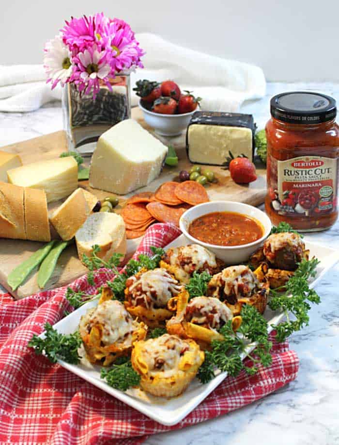 Appetizer spread with cheese board and pasta muffins.