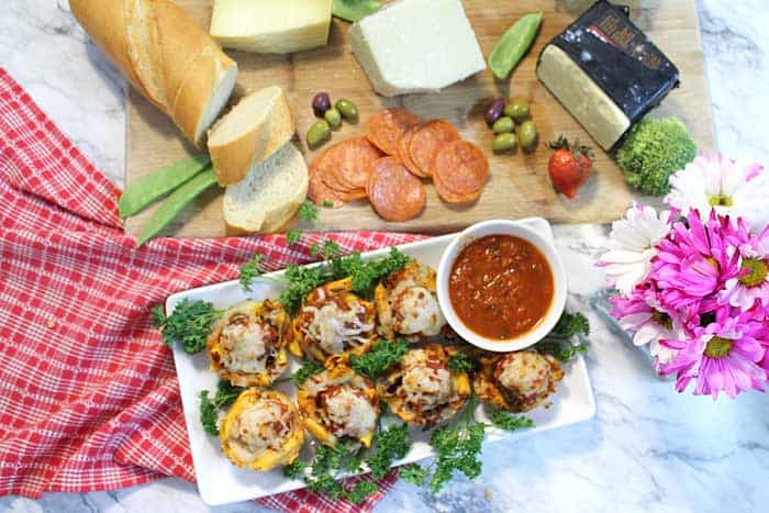 Overhead of cheese board and muffin tin Spaghetti and Meatballs.