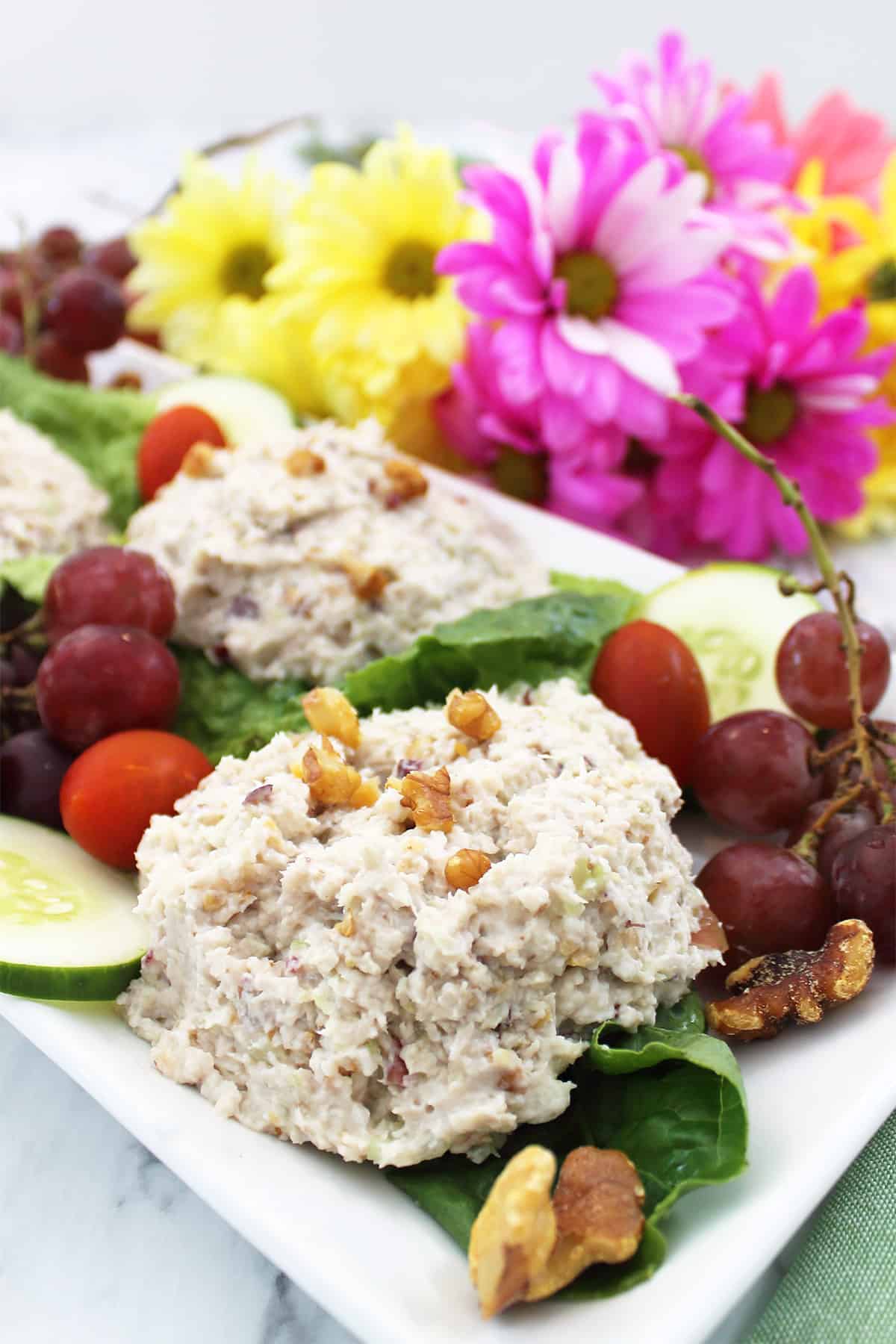 Scoops of Chicken Salad with Grapes and Walnuts on white platter.