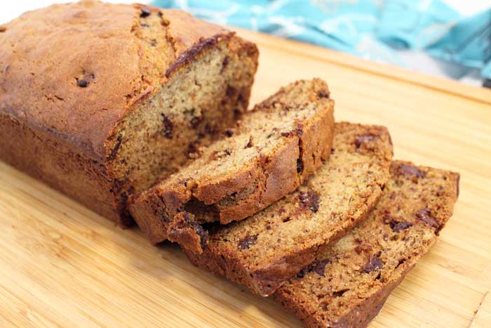 Sliced peanut butter banana bread on wooden cutting board.