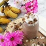 Smoothie in mason jar with red striped straw on wood.