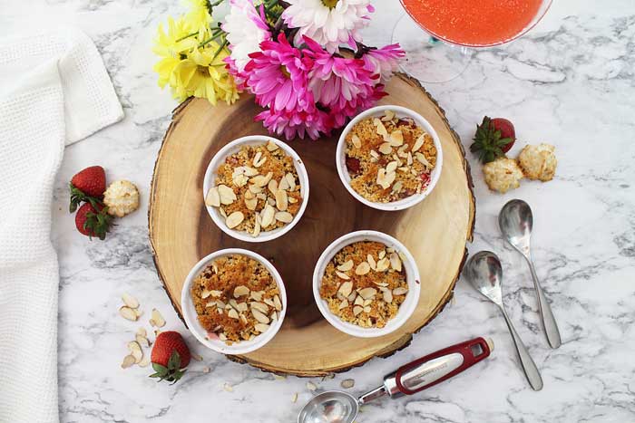 4 Baked Berry Crisps on wooden board overhead.