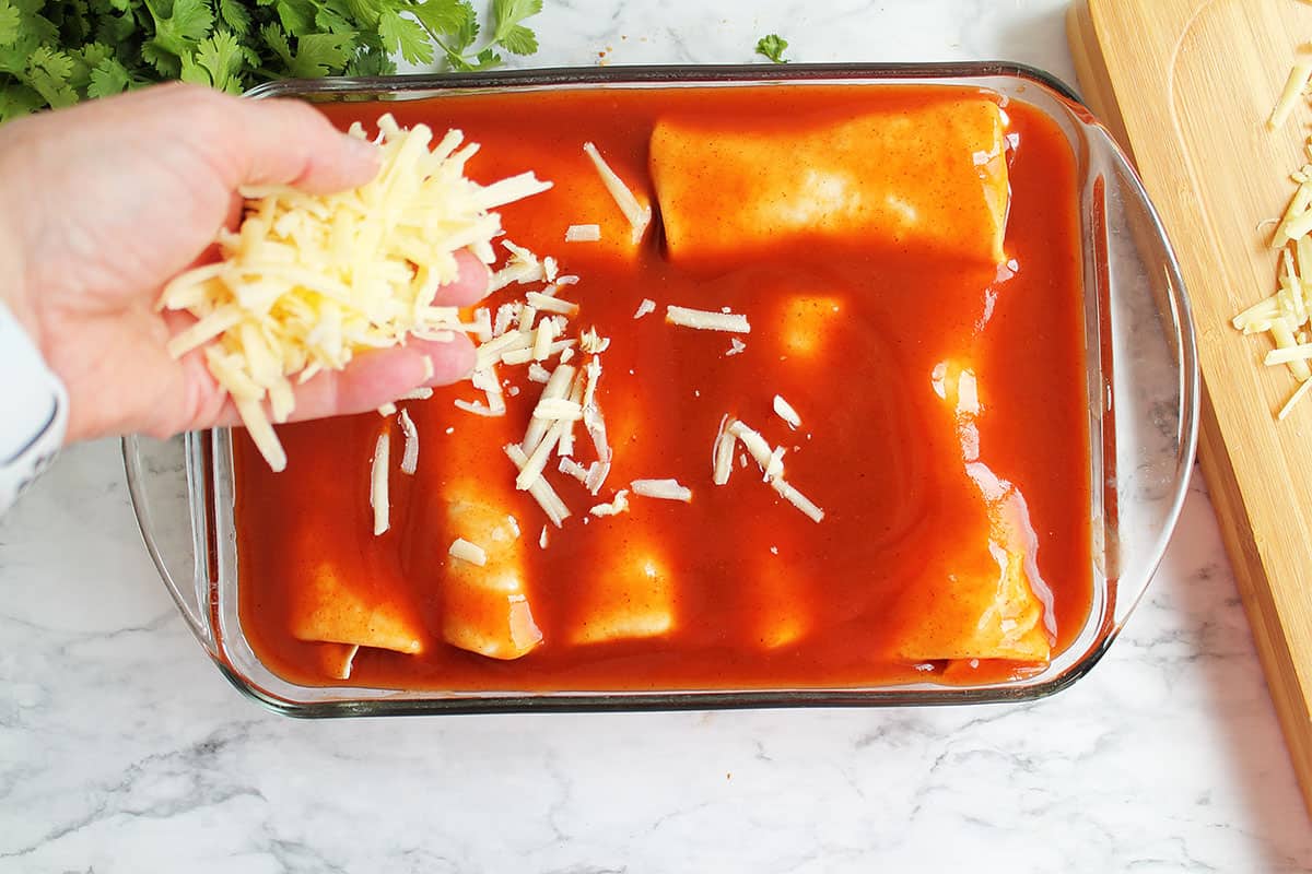 Sprinkling cheese on top of casserole.