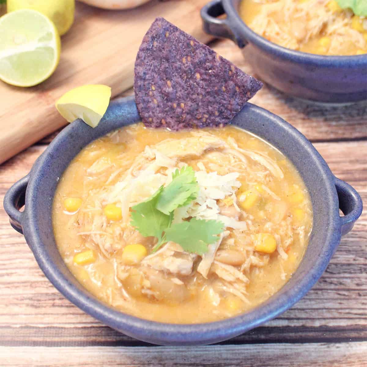Single bowl of chicken chili with corn chip garnish.
