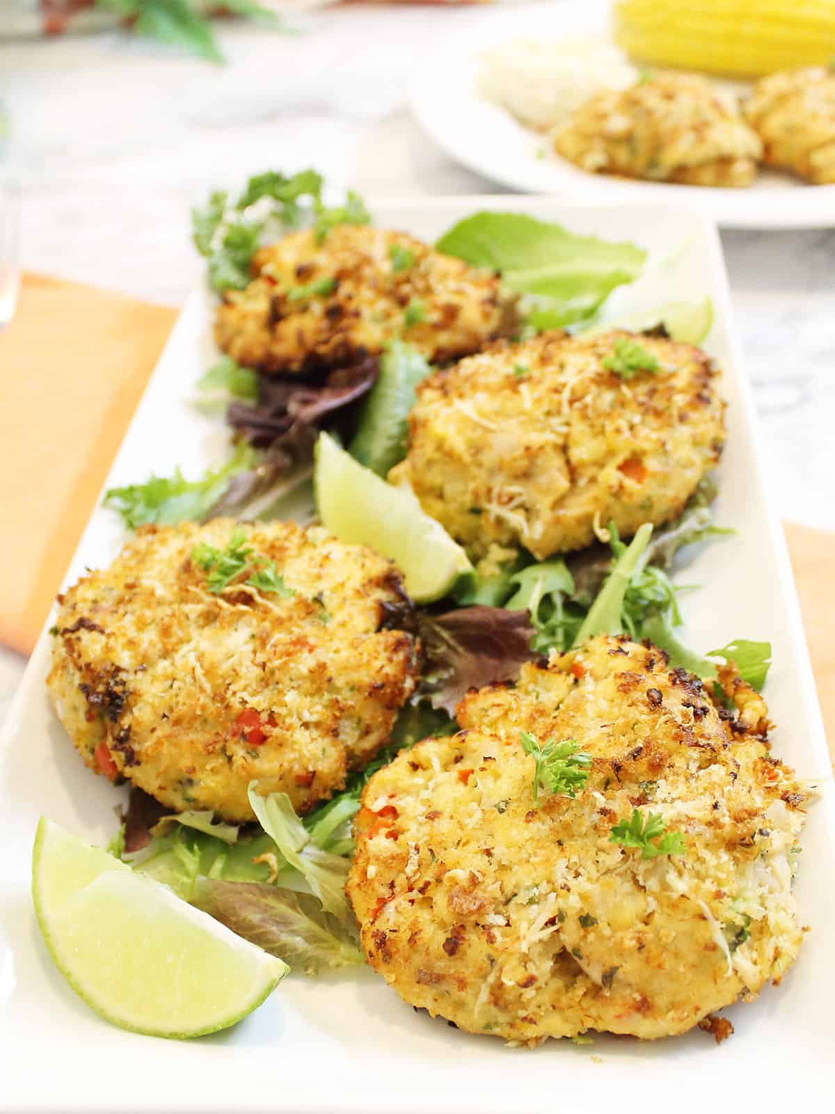 Air fryer tuna patties on white platter with greens.