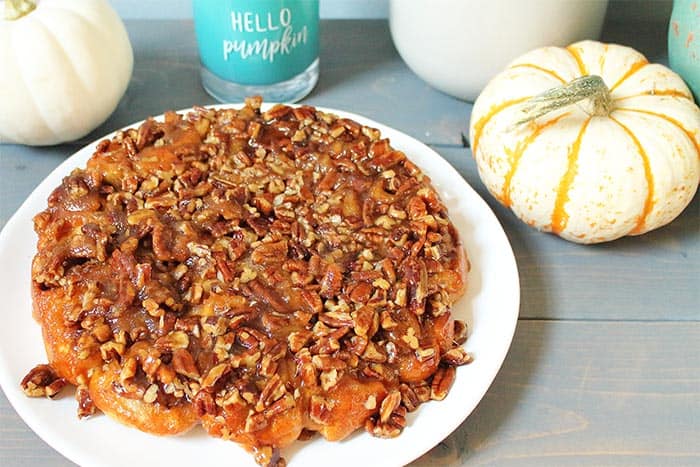 Plated easy sticky buns on white plate with gourds behind it.