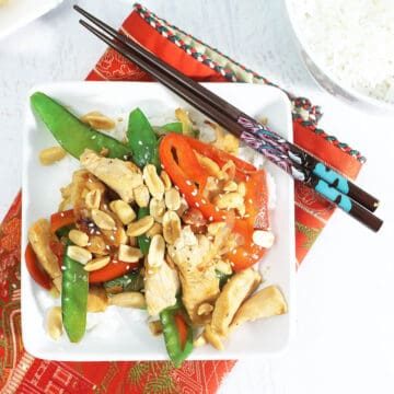 Chicken Vegetable Stir Fry on white plate with chopsticks.