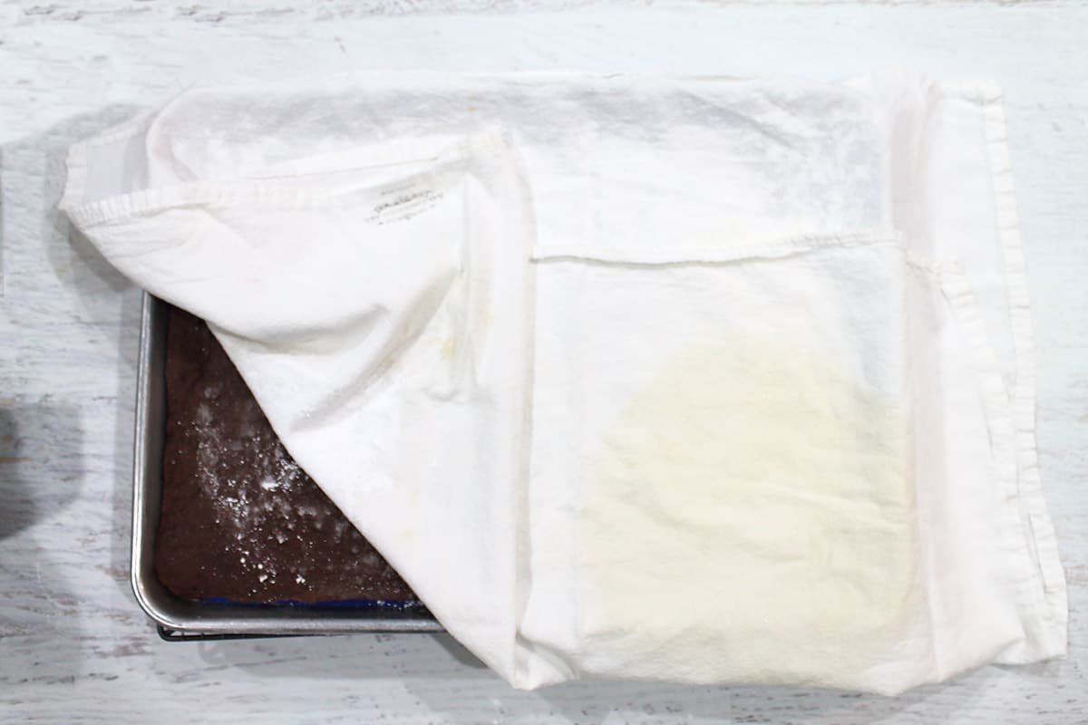 Cover cake with a towel sprinkled in confectioner's sugar.