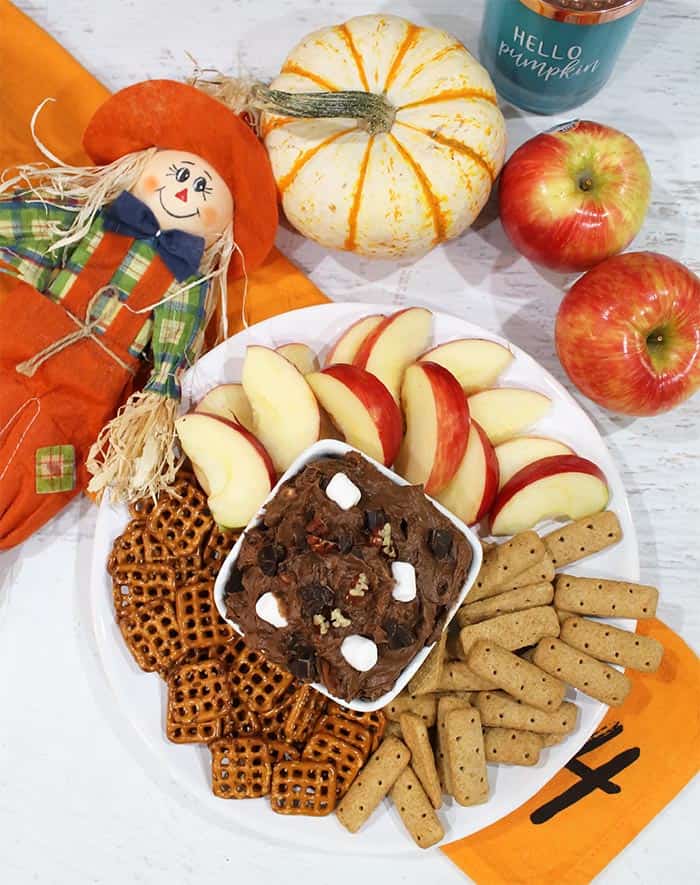 overhead of dip with dippers of apples grahams and pretzels.
