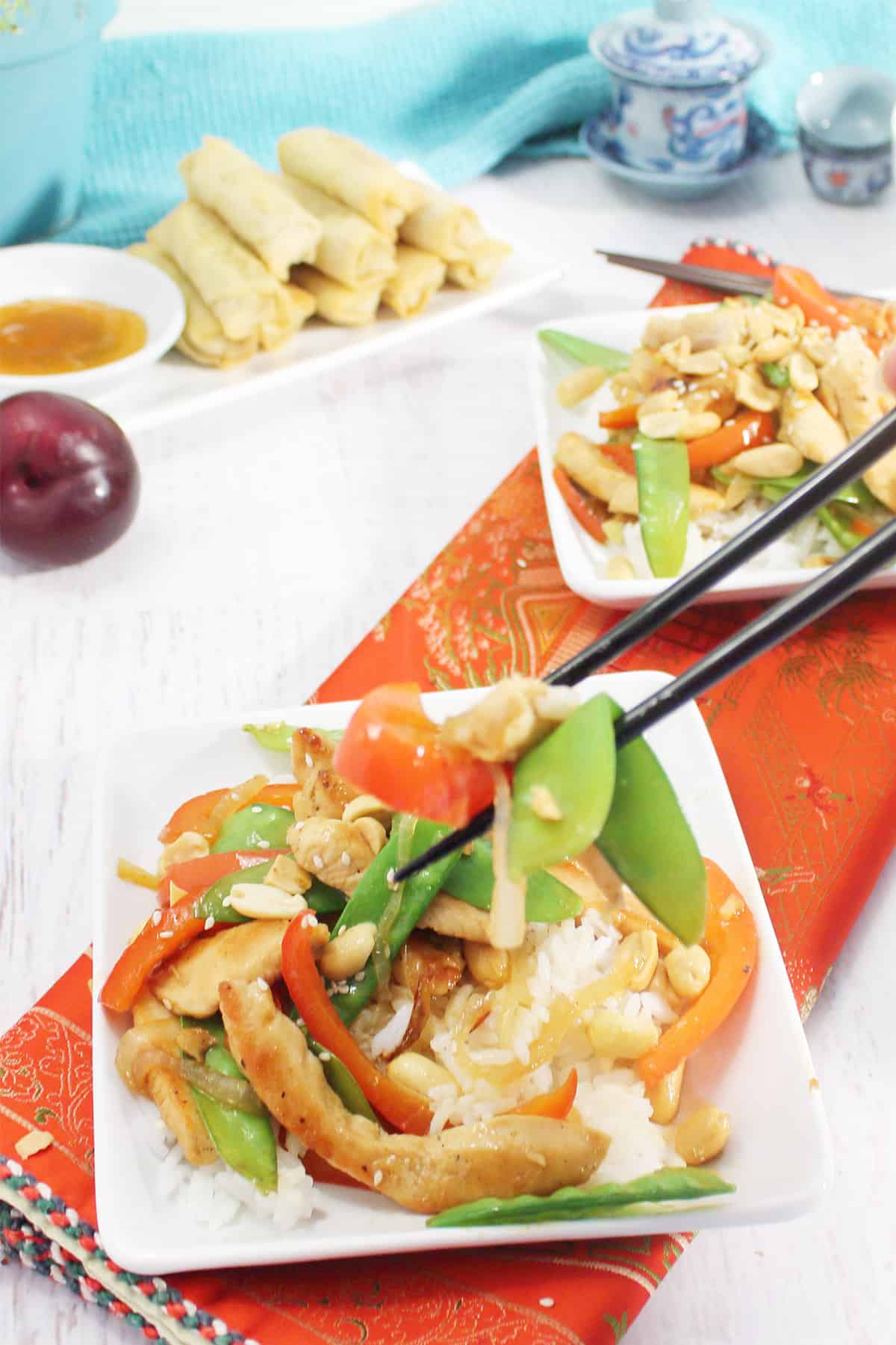Picking up chicken stir fry with chop sticks.