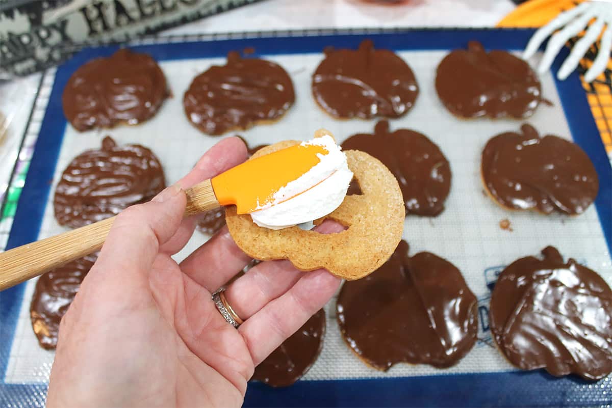 Spreading the fluff on the bottom cookie.