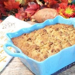 Casserole in turquoise dish with fall leaves and holiday towel in back.