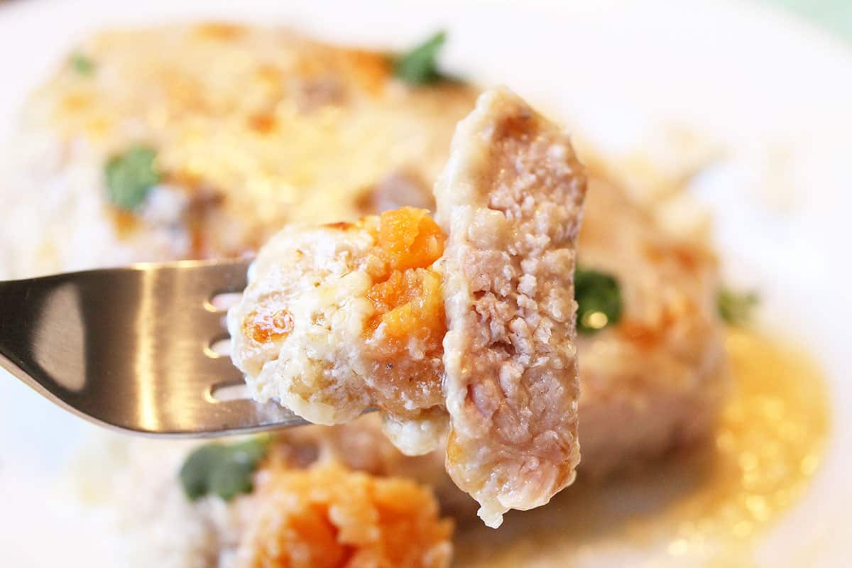 Bite of pork chop with cauliflower sweet potato tot.