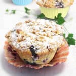 Blueberry muffin with lemon with liner pulled back.