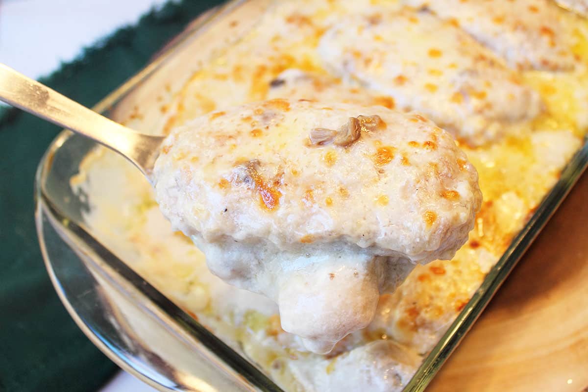 Lifting pork chop out of casserole dish.