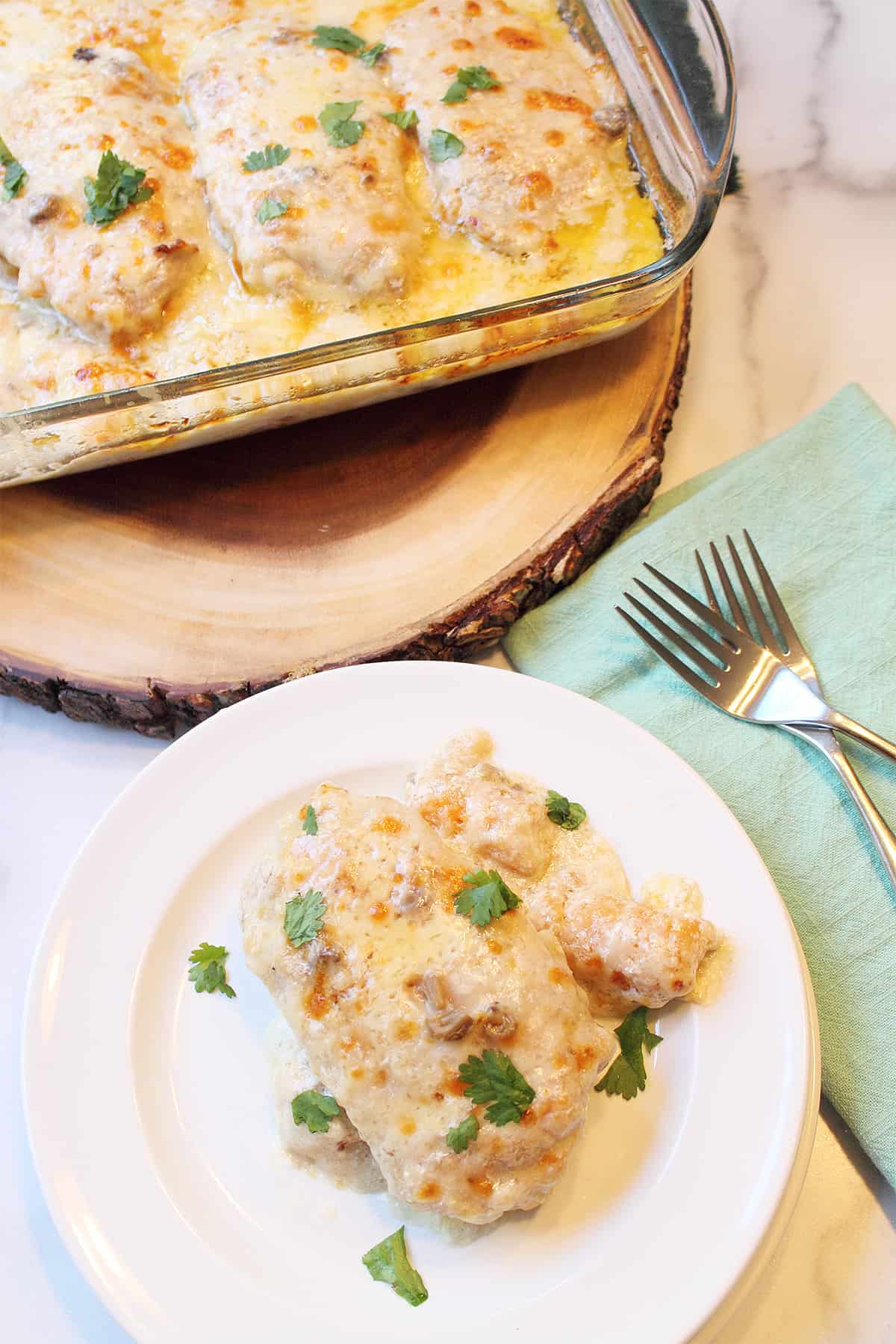 Baked Boneless Pork Chop casserole plated on white plate with casserole in background.