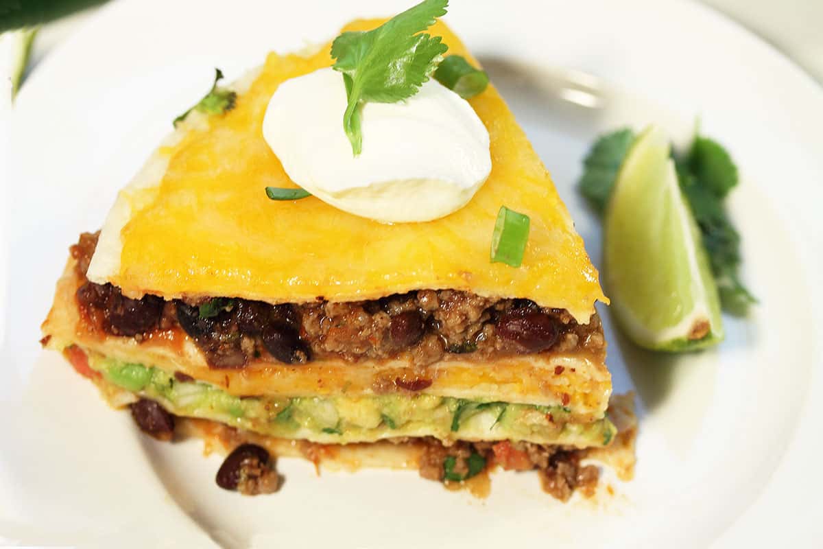 Closeup of slice of taco stack on white plate.