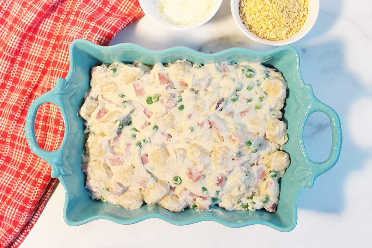 Gnocchi casserole with ham poured into casserole dish.