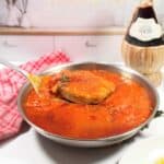 Lifting Italian pork chops out of skillet.