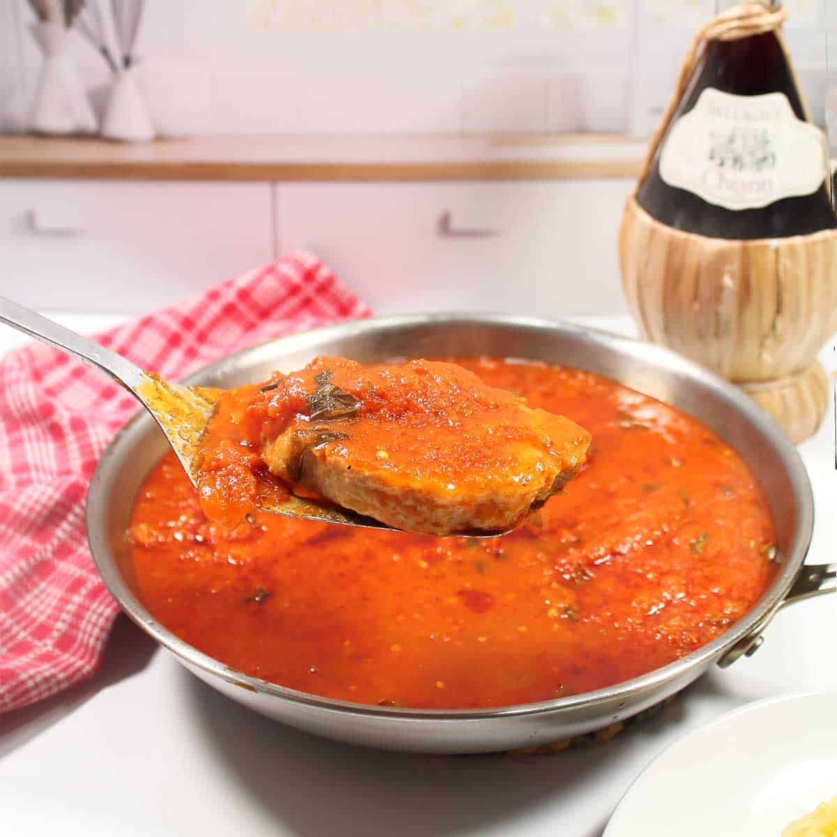 Lifting Italian pork chops out of skillet.