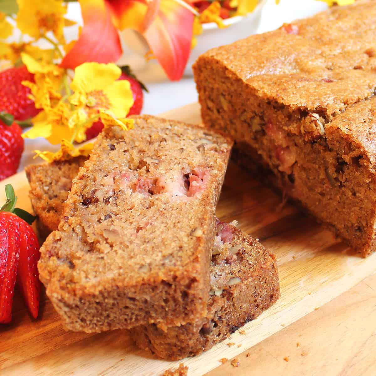 Sliced fresh strawberry bread with sliced strawberries.