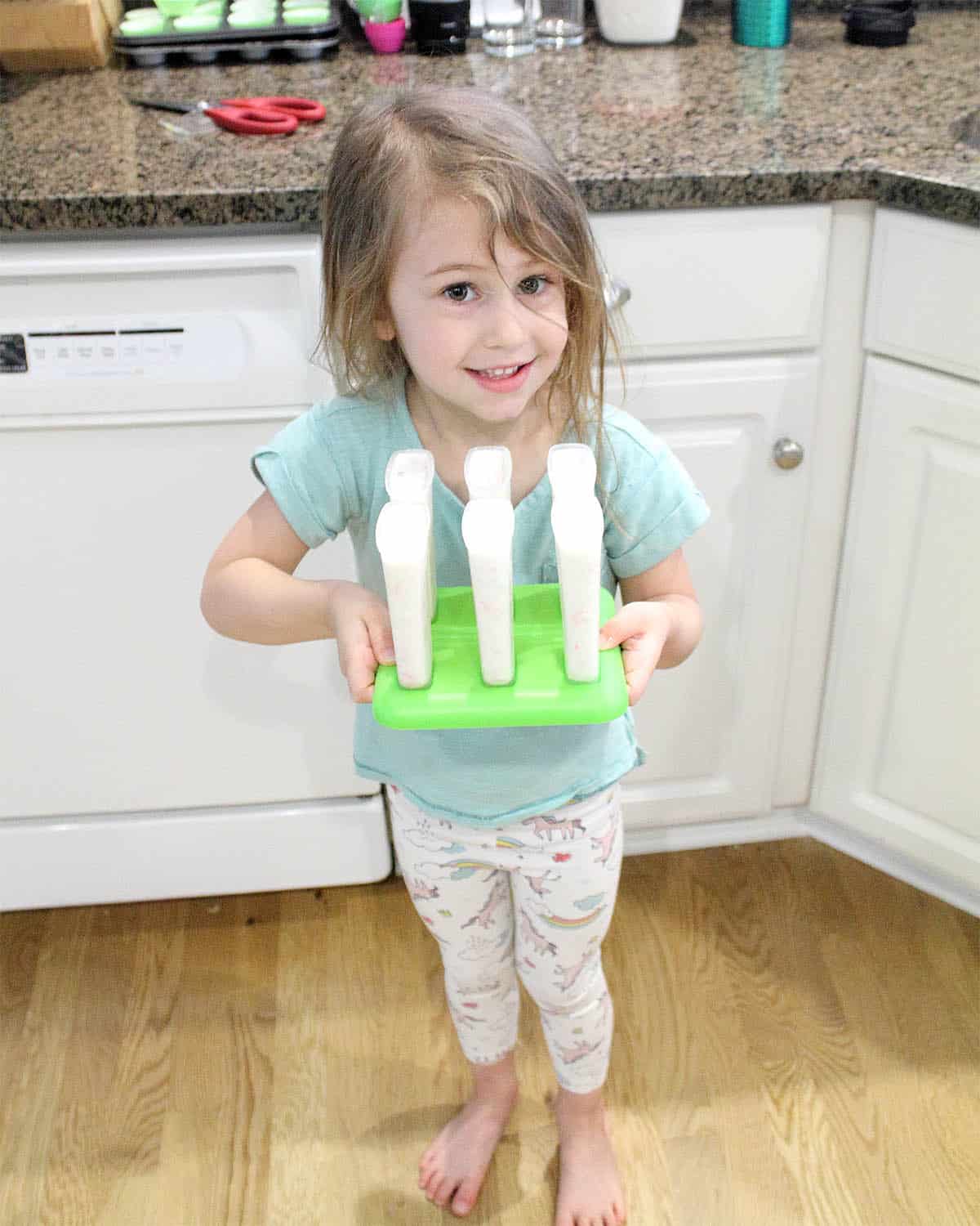 Ana carrying popsicles to freezer.
