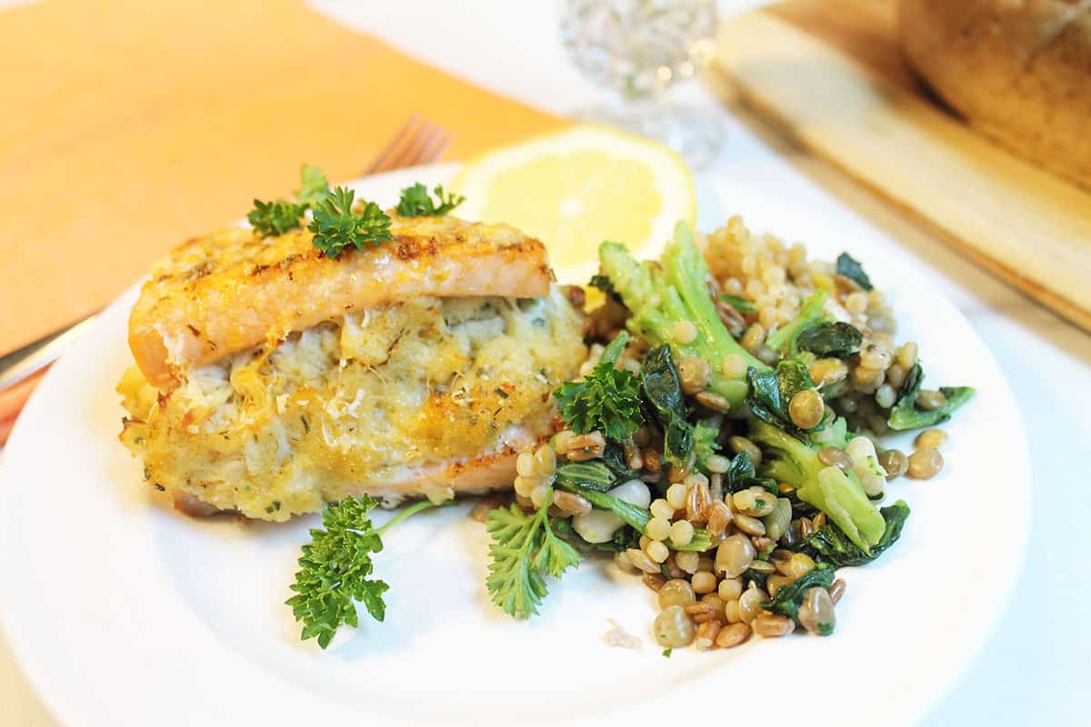 Plated stuffed salmon dinner with lentils and broccoli.
