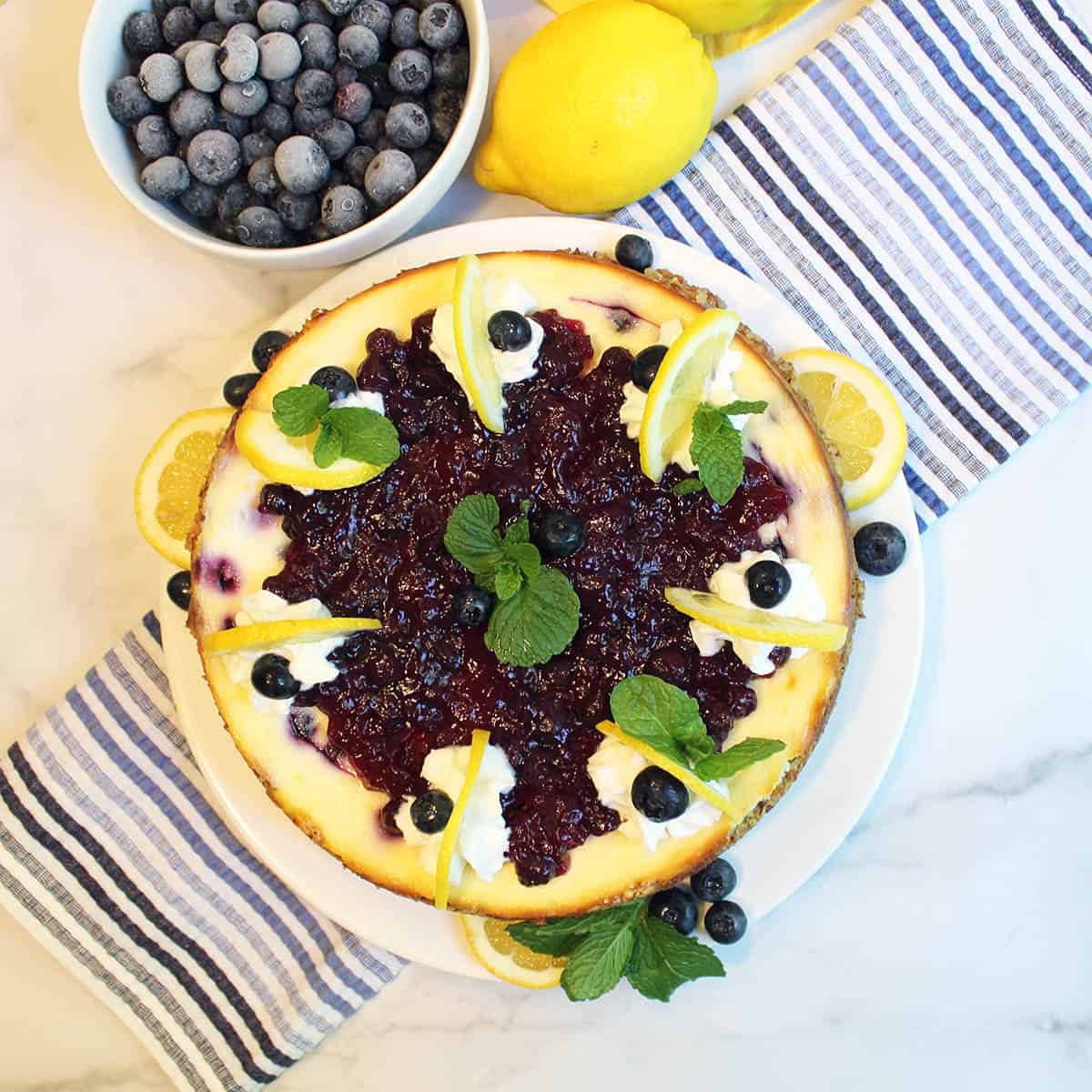 Overhead of Lemon Blueberry Cheesecake on top of blue striped towel.