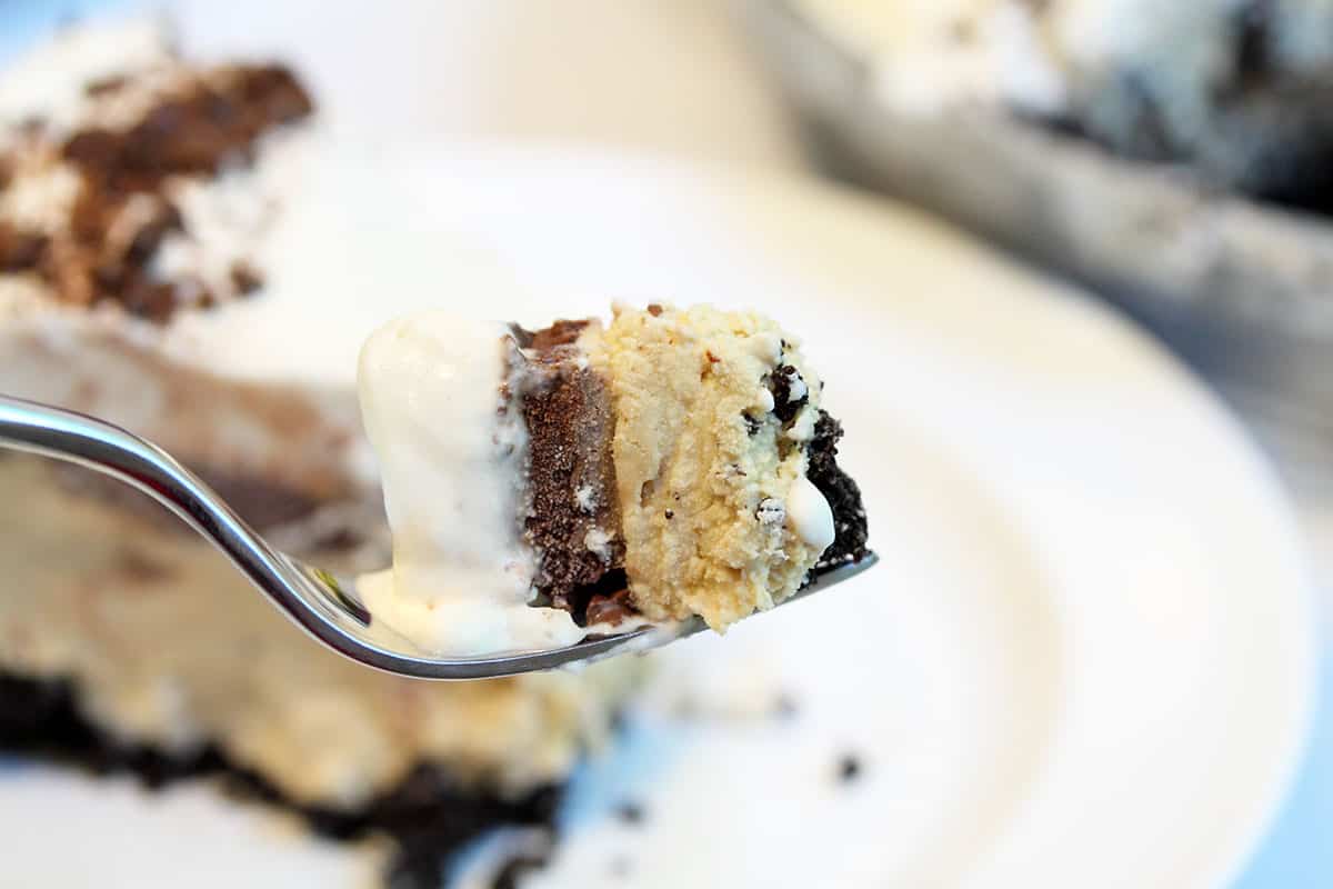 Bite on fork showing layers above slice of pie.