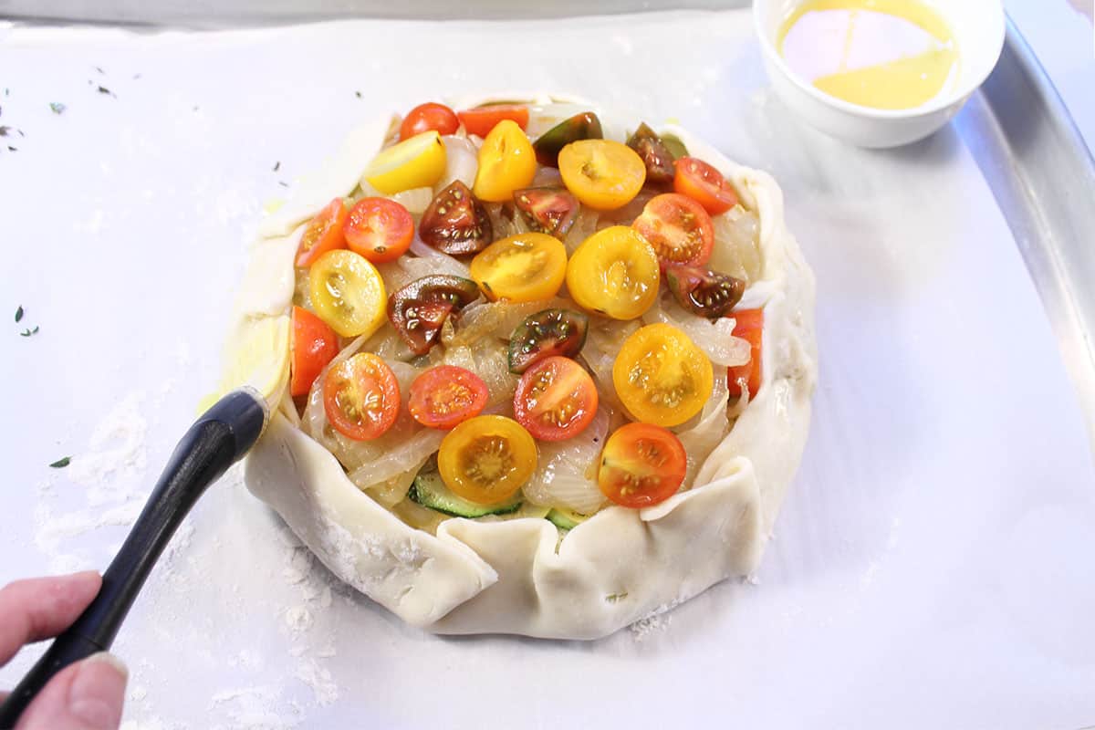 Brushing egg wash on crust.